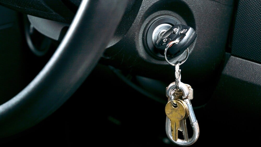 Shot of Car key and house key dangling from the ignition of car
