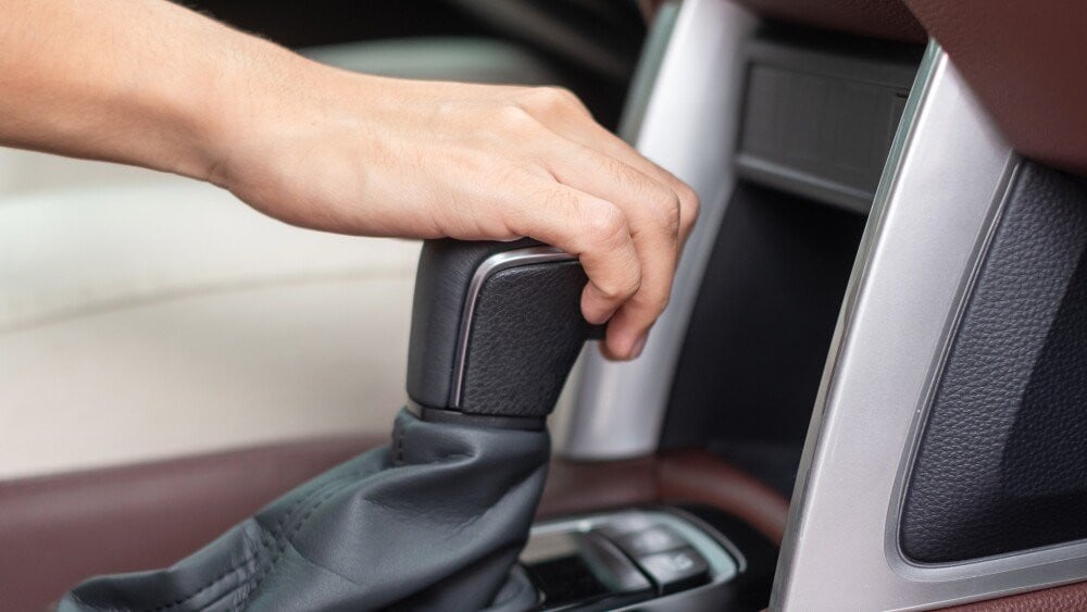 Woman driver stick shift transmission a car gear hand controlling steering wheel during vehicle moving Journey trip and safety Transportation concepts