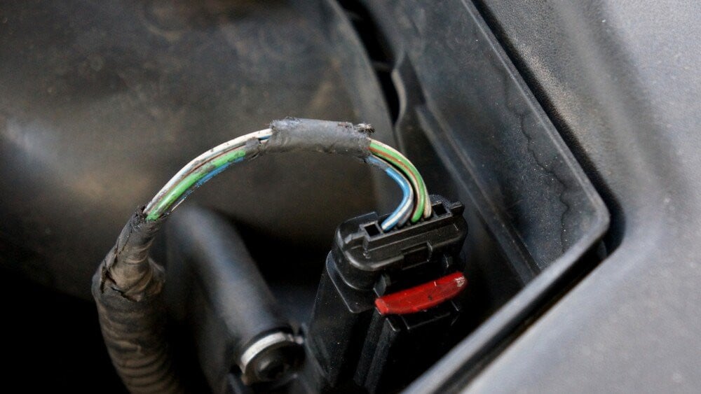 Damaged electric cord in the engine Dangerous broken power electrical cable