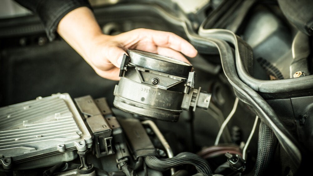 Auto mechanic working in auto repair shop. Close-up of male hands in white gloves.