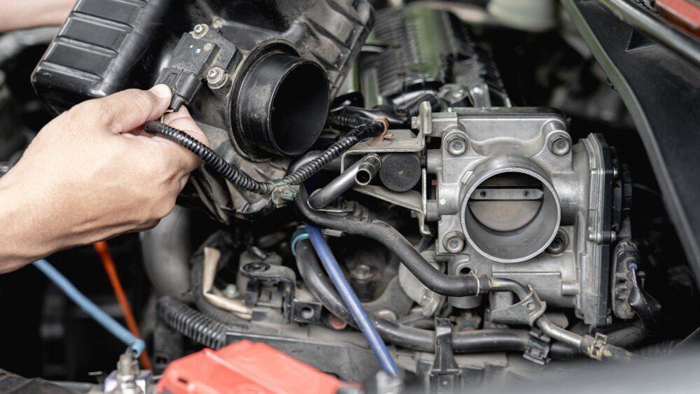 Close up old throttle Body of car in engine room with and a man hold air filler cover in car service engine throttle valve cleaning and maintenance : car service concept photo