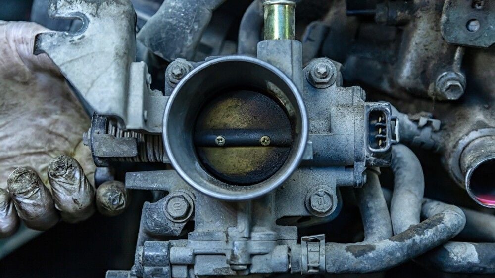 Close-up of the engine, throttle, raditor. Engine breakdown: contaminated throttle of an old car