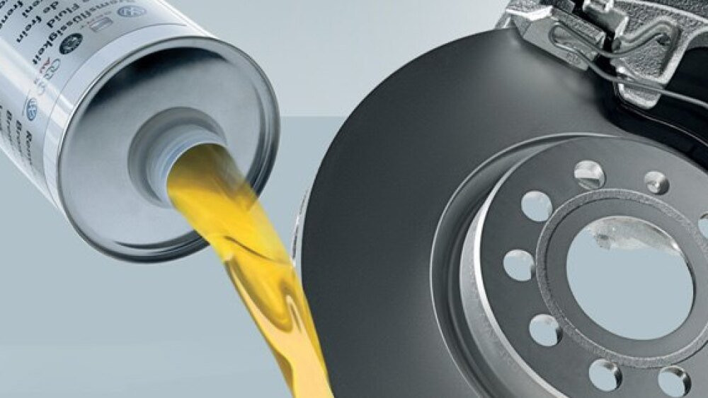 Brake fluid being poured out next to a rotor and caliper