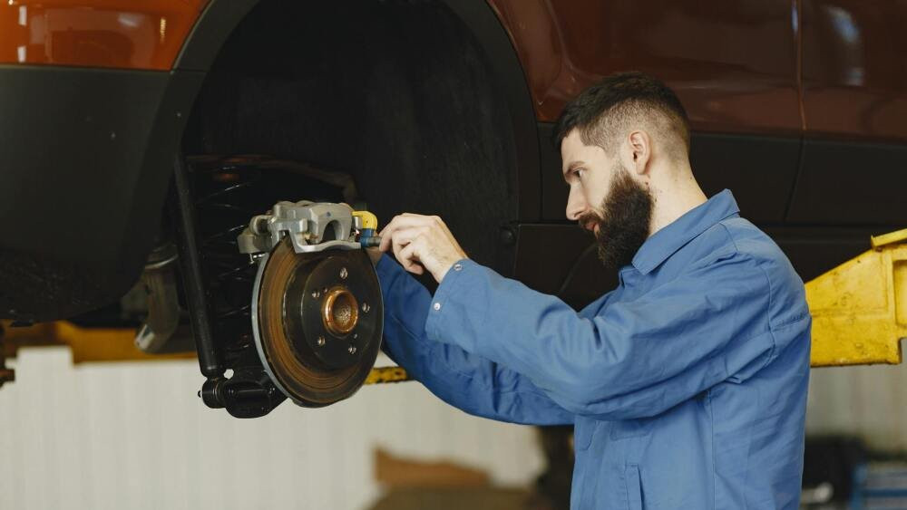 Automotive technician working on the brakes on a car