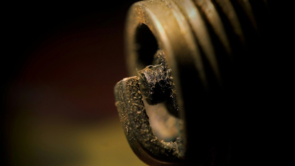 Close up image of a spark plug with deposits