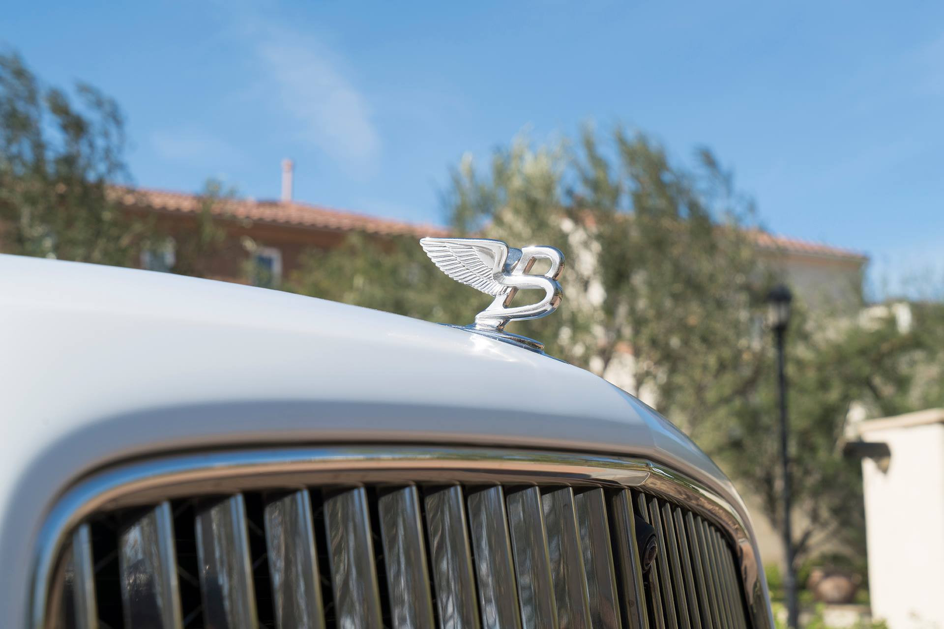 White Bentley Mulsanne with Custom Chrome Emblem - Photo by Forgiato