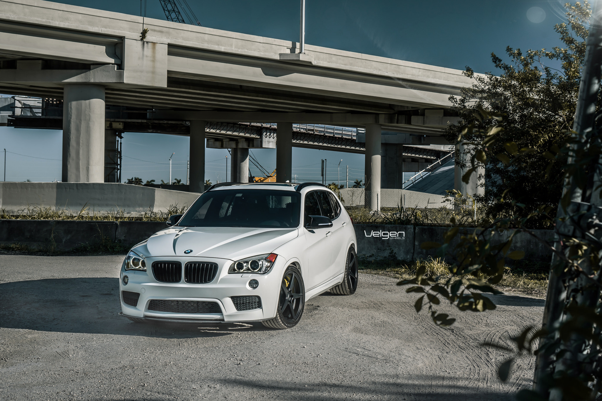 Aftermarket Projector Headlights on White BMW X1 - Photo by Velgen